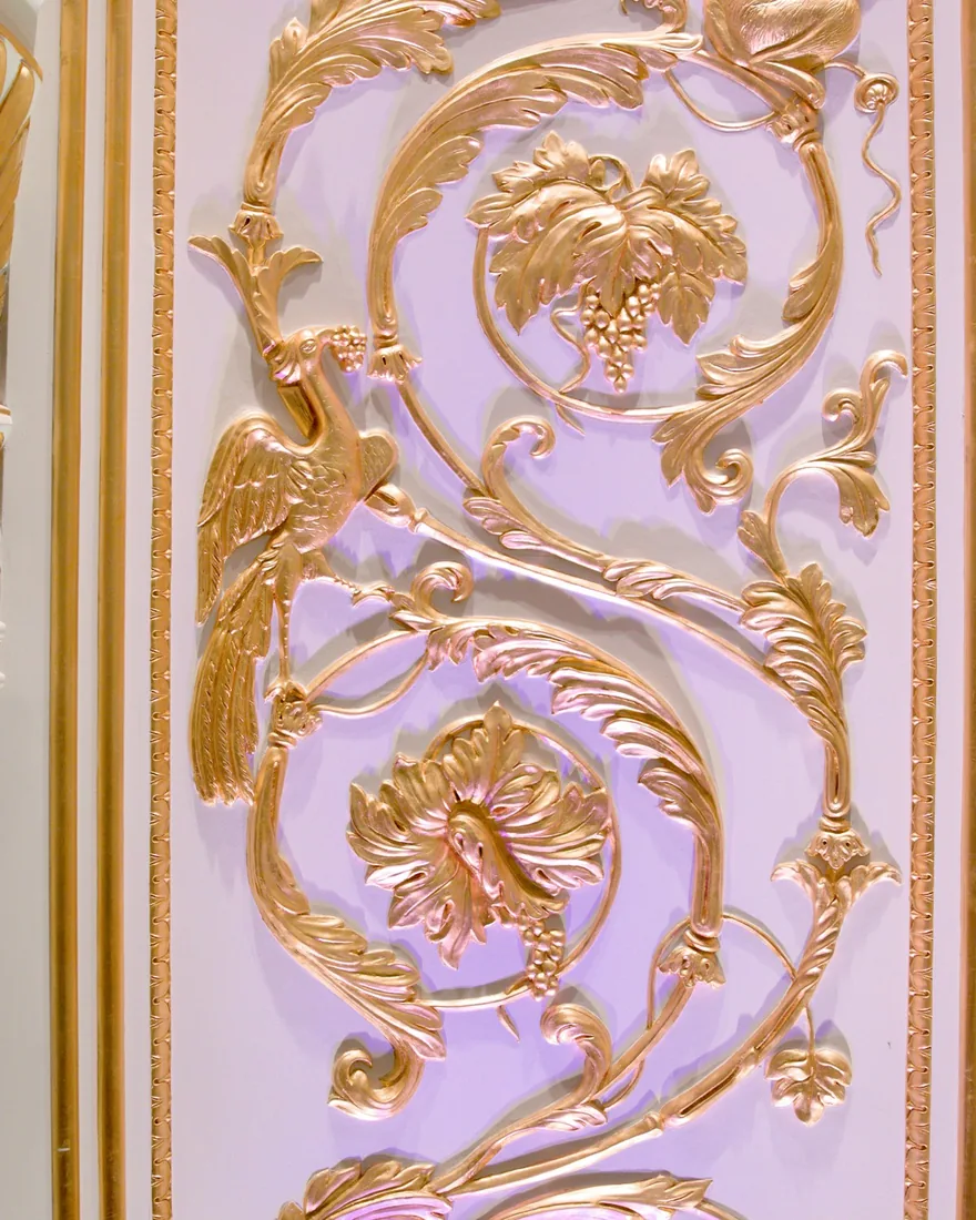 Zlacený reliéfní ornament s listy, hrozny a ptákem na světlém rámovém poli